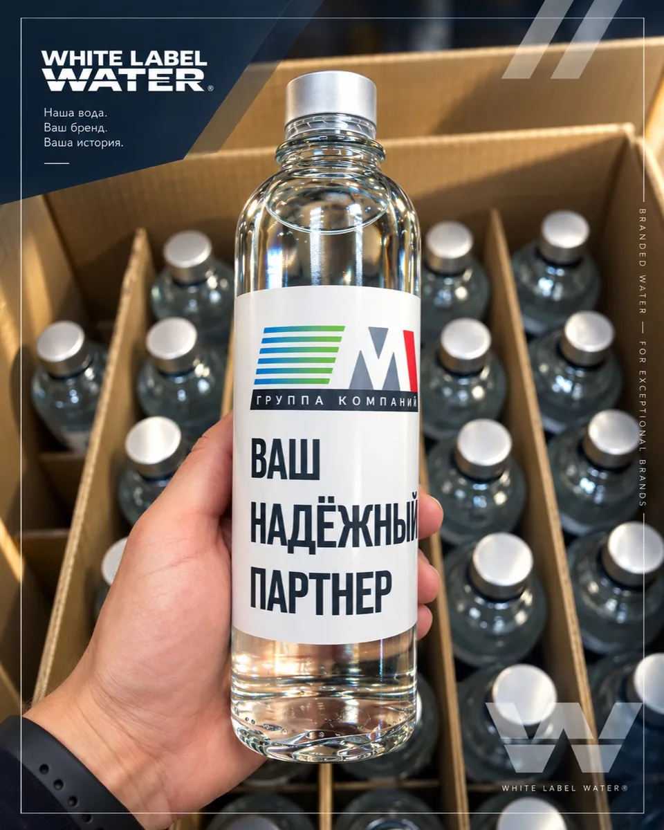 Бутылка с индивидуальной этикеткой над коробкой с разделителями и готовой партией воды